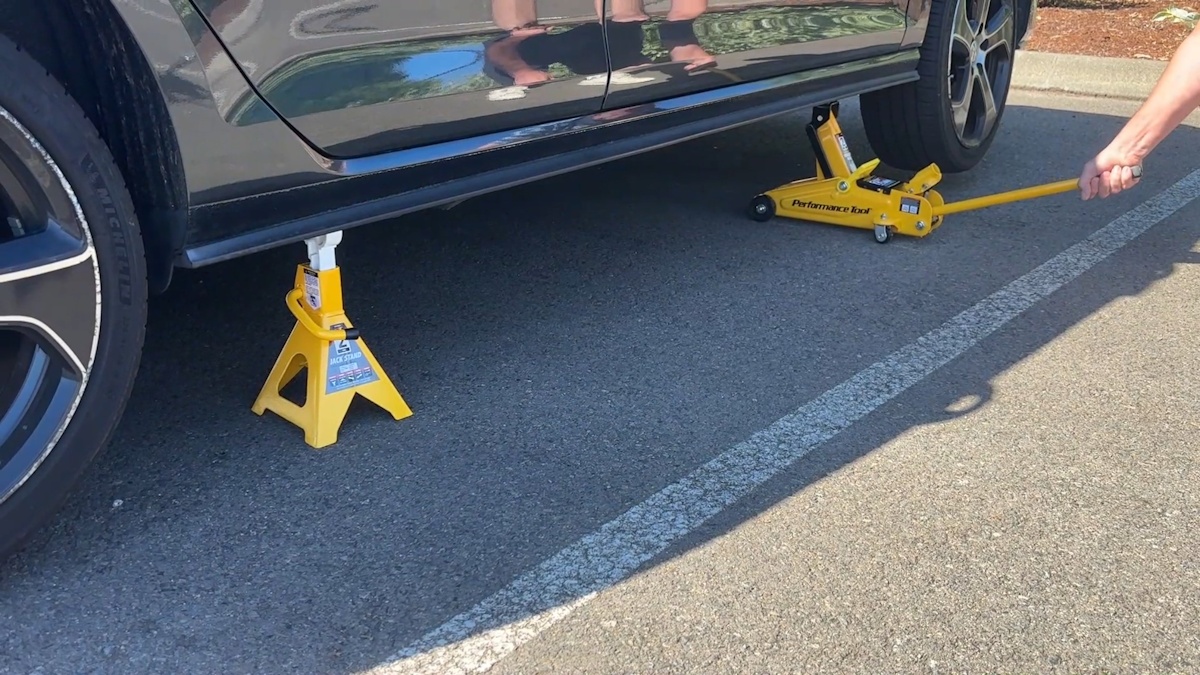 Floor jack lifting the VW Golf GTI using jack points