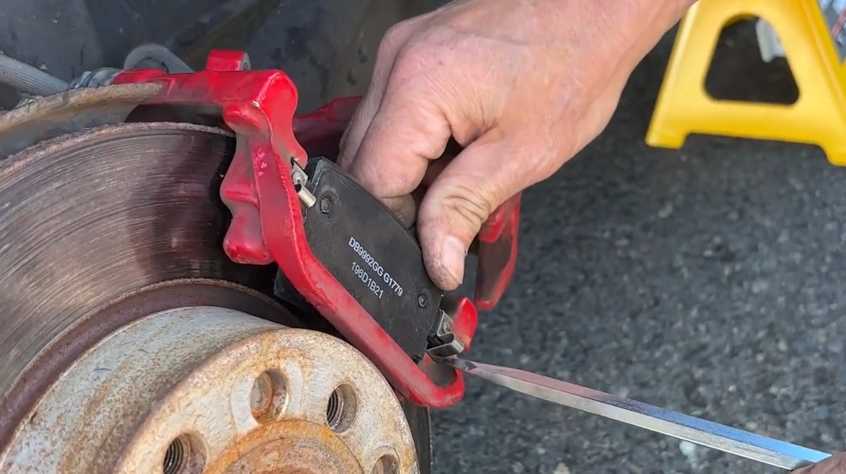 Install the replacement brake pads into the caliper bracket Installing new rear brake pads into the caliper bracket