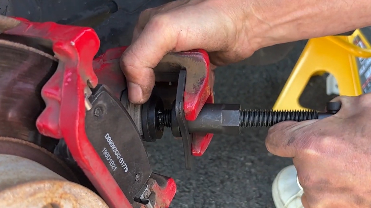 Use a brake caliper wind-back tool to retract the piston Retracting the rear brake caliper piston with a wind-back tool