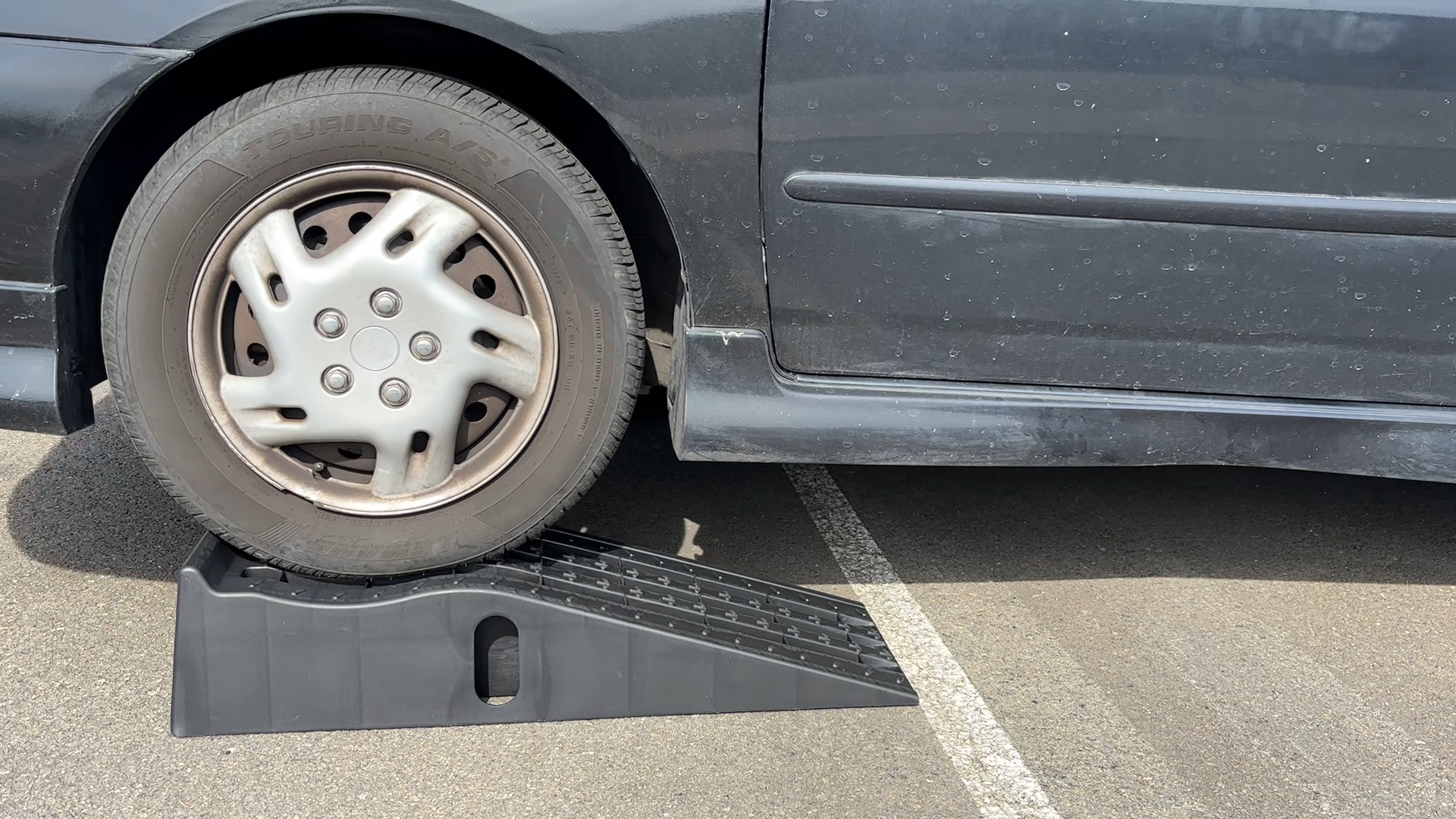 Roll the vehicle onto the ramps, and ensure it is stable and secure before working.